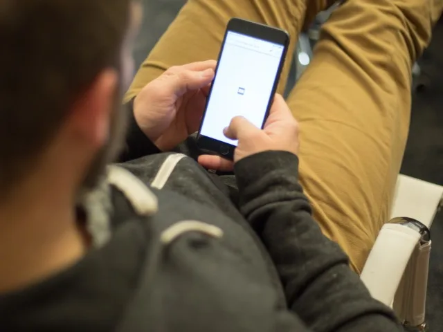Mobilalkalmazás fejlesztő a felhasználói felületet teszteli okostelefonon